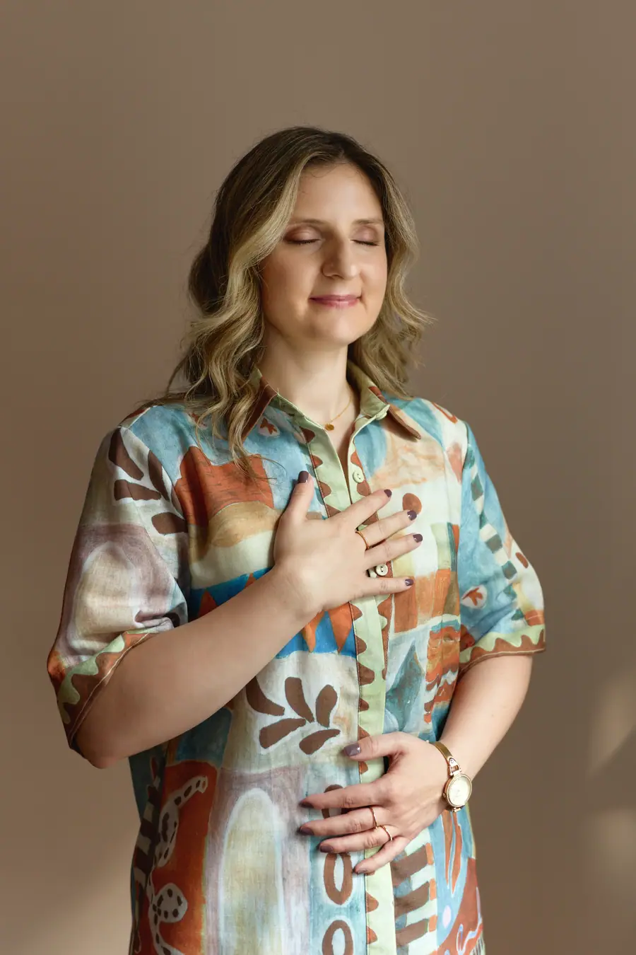 Portrait of a woman with her hand on her chest, eyes closed