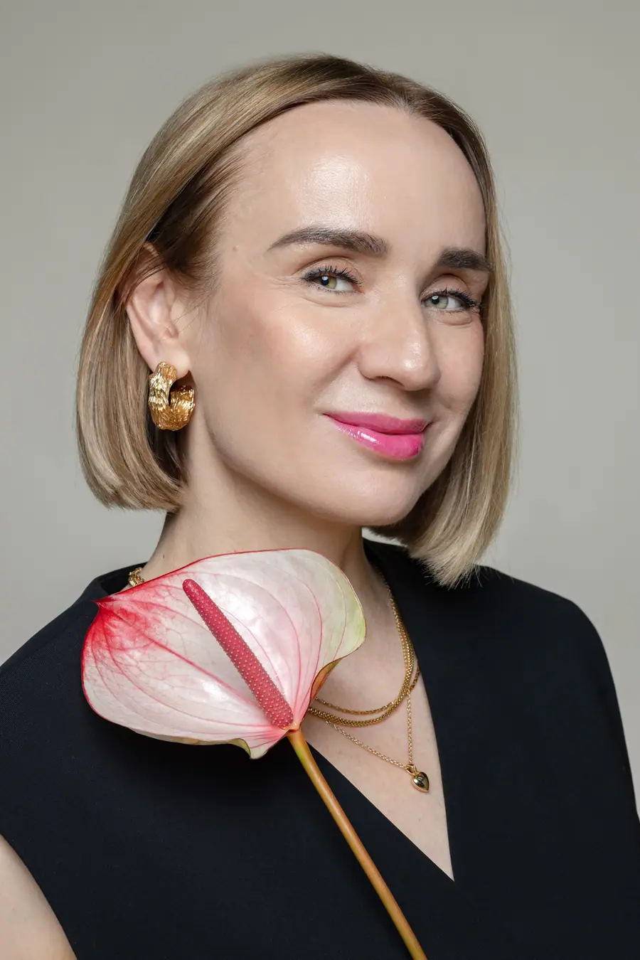 Close portrait of a woman with a pale pink flower at her shoulder